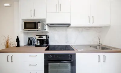 a white kitchen with a sink and a microwave at Gio Center Apartment in Rhodes Town