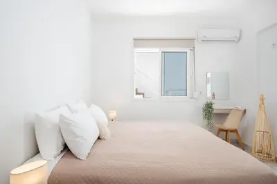 a white bedroom with a large bed with white pillows at Gio Center Apartment in Rhodes Town