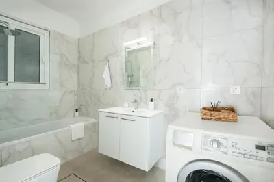 a white bathroom with a washing machine in it at Gio Center Apartment in Rhodes Town