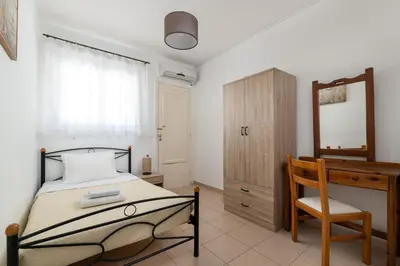 a bedroom with a bed and a desk and a mirror at Amethyst Rooms in Rhodes Town