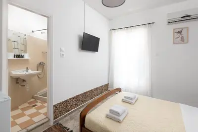 a bedroom with a bed and a bathroom with a sink at Amethyst Rooms in Rhodes Town