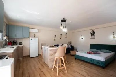a kitchen and a living room with a bed in a room at Stergios Suite with Private Jacuzzi in Kolimbia
