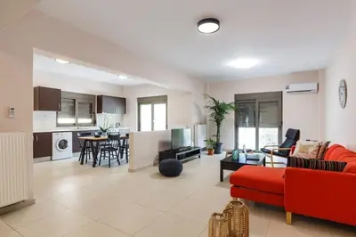 a living room with a red couch and a kitchen at J&G Rhodes city flat in Rhodes Town
