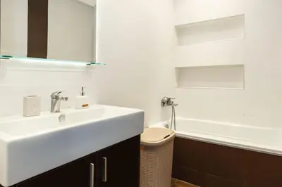 a white bathroom with a sink and a bath tub at J&G Rhodes city flat in Rhodes Town