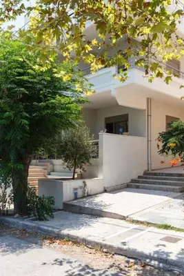 a building with stairs and a tree in front of it at J&G Rhodes city flat in Rhodes Town