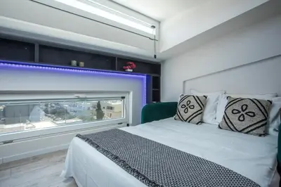 a bedroom with a white bed and a window at My Little Tiny House in Rhodes Town