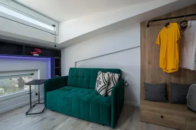 a living room with a green couch and a table at My Little Tiny House in Rhodes Town