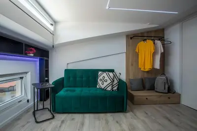 a living room with a green couch and a table at My Little Tiny House in Rhodes Town