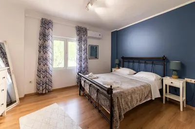 a bedroom with a bed and a blue wall at My Green Eden in Rhodes in Ialyssos