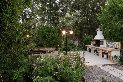 a garden with a bench and a bird house at My Green Eden in Rhodes in Ialyssos