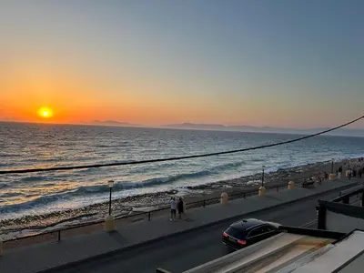 a car driving on a road next to the ocean at Melita Downtown Seaview in Rhodes Town