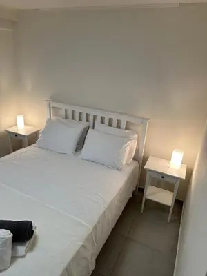 a bedroom with a white bed with two night stands at Melita Downtown Seaview in Rhodes Town