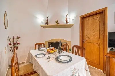 a table with a white table cloth and a bowl of fruit at Sofia Traditional House in Afantou