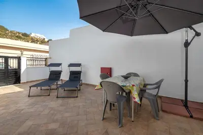 a patio with a table and chairs and an umbrella at Sofia Traditional House in Afantou
