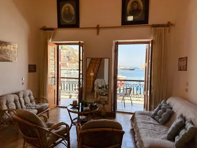 a living room with couches and a view of the ocean at Amorosa House in Symi