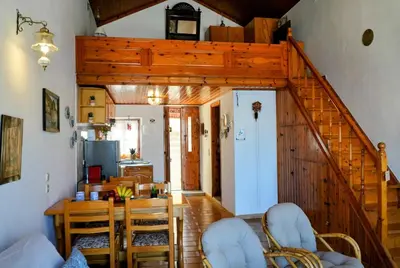 a living room with a staircase and a table and chairs at Amorosa House in Symi