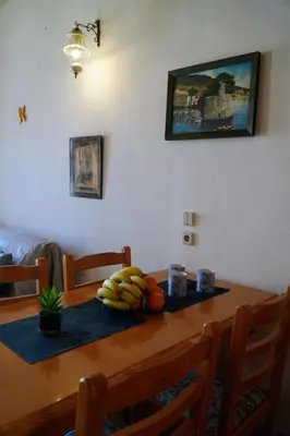a wooden table with bananas and other fruits on it at Amorosa House in Symi