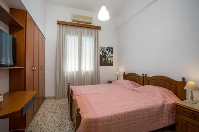 a bedroom with a bed with pink sheets and a window at Thelia Rhodian Traditional house in Rhodes Town