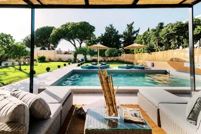 a swimming pool with a couch and a table at Costa-Aria House in Ixia