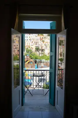 an open door with a view of a balcony at Symi Central Point in Symi