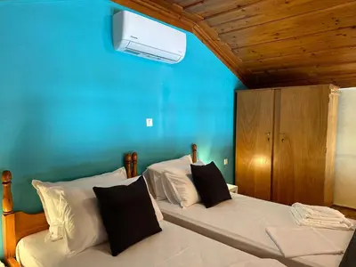 two beds in a bedroom with a blue wall at Symi Central Point in Symi