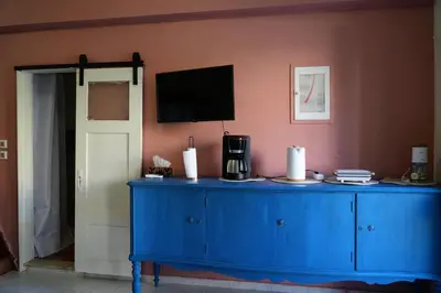 a blue dresser with a television on a wall at Symi Central Point in Symi