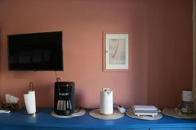 a table with a blender and a tv on a wall at Symi Central Point in Symi