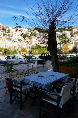 a blue and white table and chairs with a tree at Symi Central Point in Symi