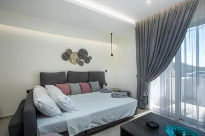 a bedroom with a bed and a large window at Matsi Suites in Faliraki