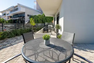 a glass table with a vase on it on a patio at Aegean Escape Luxury Apartment in Rhodes Town