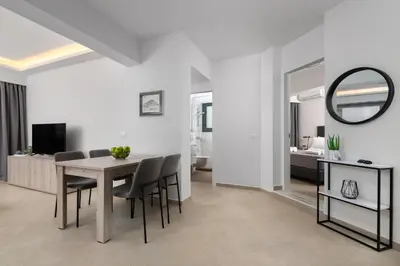 a dining room and living room with a table and chairs at Aegean Escape Luxury Apartment in Rhodes Town