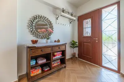 a hallway with a mirror and a wooden door at Kira's Lovely Villa Massari in Haraki