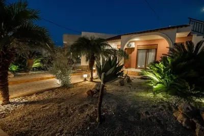 a house with palm trees in front of it at Kira's Lovely Villa Massari in Haraki