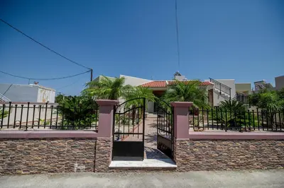 a gate to a house with palm trees at Kira's Lovely Villa Massari in Haraki