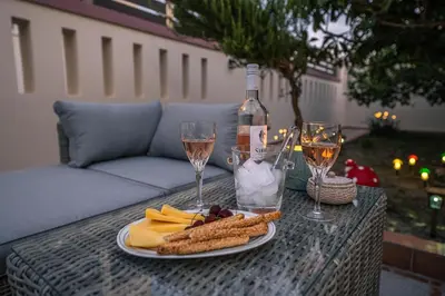 a table with a bottle of wine and a plate of food at Kira's Lovely Villa Massari in Haraki