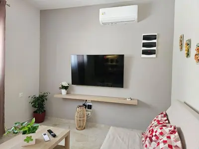 a living room with a tv on the wall at Nereides Apartments Rhodes in Kremasti