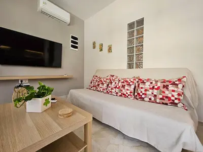 a living room with a bed and a flat screen tv at Nereides Apartments Rhodes in Kremasti