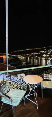a table and chairs on a balcony at night at 89 Steps Symi in Symi
