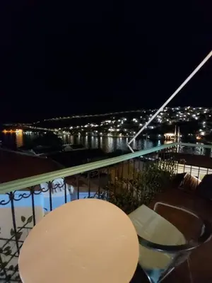 a table and chairs on a balcony at night at 89 Steps Symi in Symi