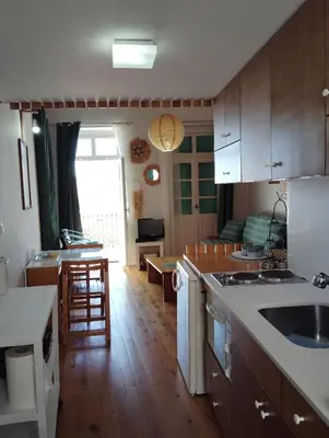 a kitchen with wooden floors and a kitchen with a table at 89 Steps Symi in Symi