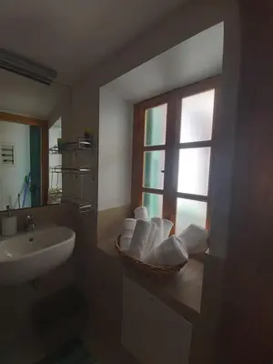 a bathroom with a sink and a basket of towels at 89 Steps Symi in Symi