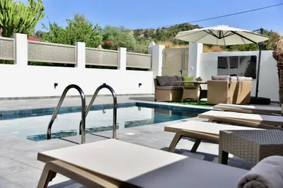 a swimming pool with lounge chairs and an umbrella at Melia Casa in Rhodes Town