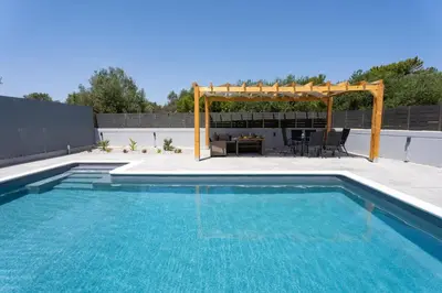a swimming pool with a gazebo and a patio at Villa Pasadra in Afantou