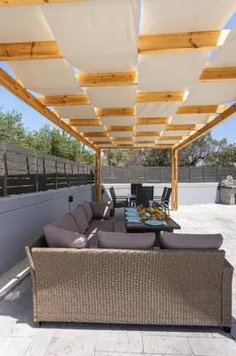 a patio with a couch and table on a roof at Villa Pasadra in Afantou