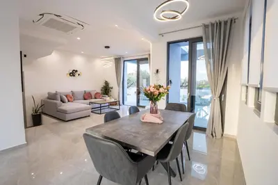 a living room with a table and chairs and a couch at Villa Pasadra in Afantou