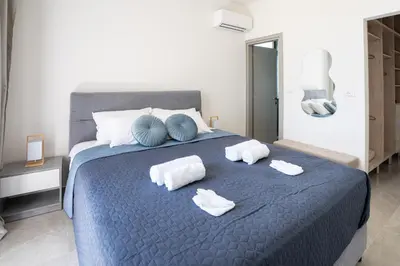 a bedroom with a blue bed with towels on it at Villa Pasadra in Afantou
