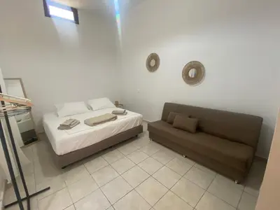a small bedroom with a bed and a couch at Isola Studio 1 in Rhodes Town
