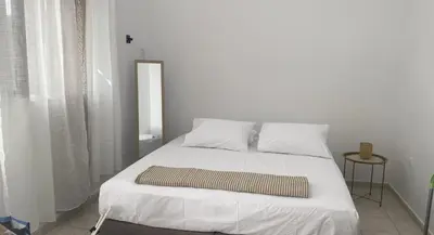 a bed with white sheets and pillows in a room at Isola Studio 1 in Rhodes Town