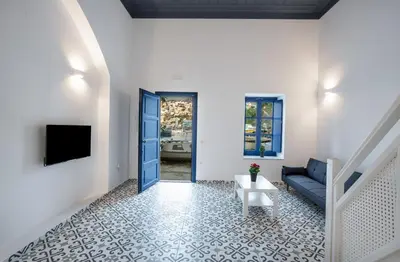 a living room with a blue couch and a table at Porto Harani Seaside Apartments in Symi