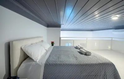 a bedroom with a bed with a teddy bear on it at Porto Harani Seaside Apartments in Symi